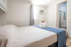 une chambre avec un grand lit blanc avec des serviettes dessus dans l'établissement Pousada Vila Merced, à Búzios 3 autres photos