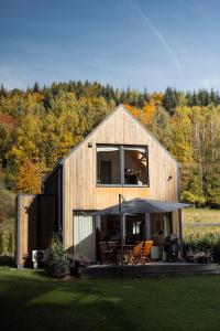 扎沃亚Babia Rest - całoroczny domek z balią z jacuzzi的木屋设有天井和遮阳伞