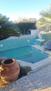 ein Pool mit einer Vase daneben in der Unterkunft Network Forio ischia 4 stelle promo pensione completa con bevande in Ischia