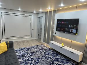 a living room with a large screen tv on a wall at Сатпаева, Телецентр in Taraz