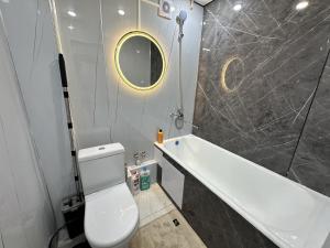 a bathroom with a toilet and a tub and a sink at Сатпаева, Телецентр in Taraz