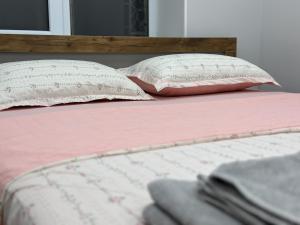 a bed with two pillows and a pink blanket at Сатпаева, Телецентр in Taraz
