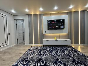 a living room with a white table and a black rug at Сатпаева, Телецентр in Taraz