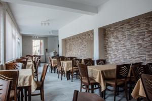 a dining room with tables and chairs and a brick wall at Dzhorgovata Guesthouse in Govedartsi