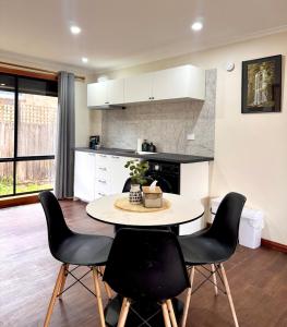 a kitchen with a table and chairs in a room at Comfortable 2BR Home in Hallam in Hallam