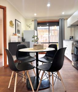a table with black chairs in a kitchen at Comfortable 2BR Home in Hallam in Hallam +4 photos