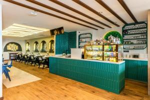 a restaurant with a blue counter and chairs at Elysian Airport Hotel & Restaurant in Arnavutköy