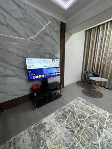 a living room with a large screen tv in a room at Уютный Апартамент Новостройка 舒适公寓 in Tashkent