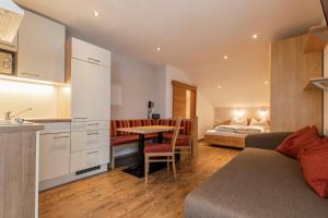 拉迪斯EDELWEISS Ladis的一间厨房和一间带床和桌子的卧室