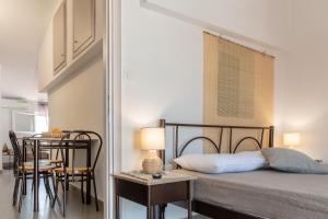a bedroom with a bed and a table with chairs at Dore Appartments in Nea Fokea