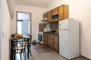 a kitchen with a white refrigerator and a table at Dore Appartments in Nea Fokea