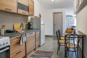 a kitchen with a table with chairs and a refrigerator at Dore Appartments in Nea Fokea