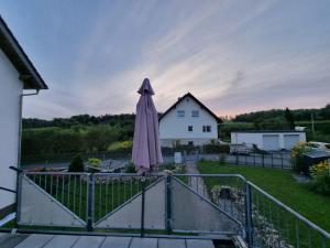 an umbrella sitting on a balcony with a house at 2-Zimmer-Apartment mit Küche und Bad im Landhaus in Ortsrandlage in Ober-Ramstadt