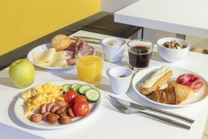 stół śniadaniowy z talerzami jedzenia i napojów w obiekcie B&B Hotel Roma San Lorenzo Termini w Rzymie