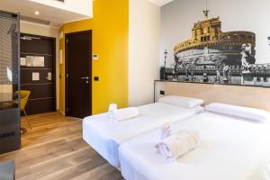 2 łóżka w pokoju z żółtymi ścianami w obiekcie B&B Hotel Roma San Lorenzo Termini w Rzymie
