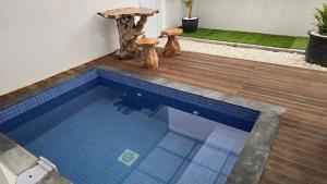 a swimming pool with a table and two stools at Probosiwi Resort Syariah in Talunombo