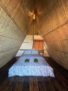 高龙撒冷岛Sea PoeTree的帐篷内的一张床位,上面有两个绿色枕头 更多8张照片