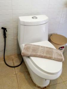 a white toilet in a bathroom with a hose at The Sea @ Lanta Hotel in Ko Lanta +106 photos