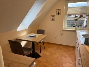 Ferienhaus Zum Gässchen في فايسنفلس: مطبخ وغرفة طعام مع طاولة ونافذة