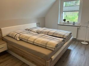 Ferienhaus Zum Gässchen في فايسنفلس: سرير وبطانية منقوشة عليه في غرفة النوم