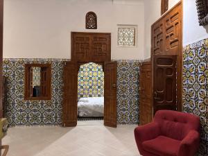 uma sala de estar com uma cadeira vermelha e um quarto em Riad Roqia em Rabat mais 26 fotografias