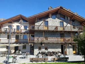 a large stone building with balconies and tables at La Tour in Oyace