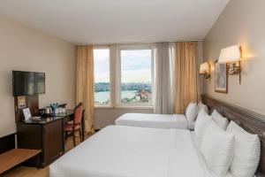 a hotel room with two beds and a window at Pera Rose Hotel & SPA in Istanbul +78 photos