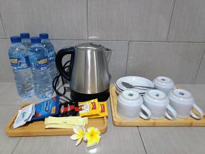 a table with two wooden cutting boards with a coffee pot and water at Rini hotel in Lovina