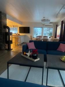 My Home Kaldfjorden في ترومسو: غرفة معيشة مع أريكة زرقاء وطاولة