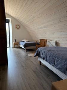 Un dormitorio abuhardillado con dos camas y un sofá. en Gîte Auberoques Aveyron- maison indépendante- classée 3 étoiles, en Les Fonds