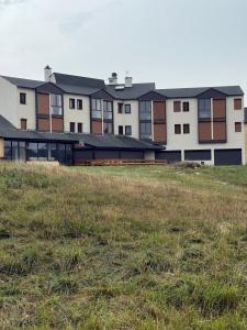 a row of buildings with a field in front of it at Cozy Lac - Puyvalador in Puyvalador
