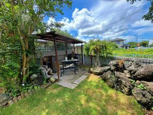 a gazebo with a table in a yard at 九十九里シーサイドヴィラ in Tōganemachi