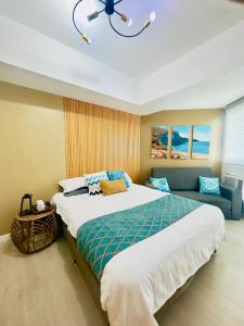 a bedroom with a large bed and a couch at Kaiah's Haven at Azure North San Fernando Pampanga in San Fernando