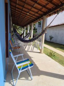 een hangmat en een stoel op een veranda bij Chalés Brisa do Mar in Amontada