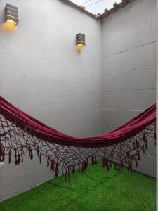 a room with a red curtain and green grass at Suíte privativa Vila Dom Pedro in Paraty