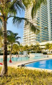 una piscina con palme e alti edifici di Kaiah's Haven at Azure North San Fernando Pampanga a San Fernando