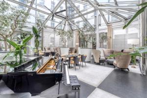 a conservatory with tables and chairs and plants at H15 Boutique Hotel, Warsaw, a Member of Design Hotels in Warsaw
