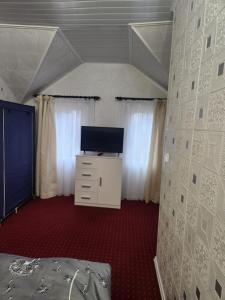 una camera da letto con un letto e una TV in una stanza di Casa Edimar a Sboghiţeşti Altre 14 foto