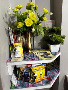 ein Regal mit einer Vase voller gelber Blumen in der Unterkunft Wander pine homestay in Darjeeling + 10 Fotos