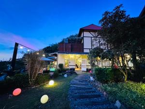 a house with a pathway leading to the front yard at Yue Ya Villa in Puli