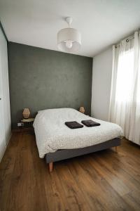 布里昂松Appartement très calme 2 chambres avec parking et jardin privé sur les hauteurs de Briançon的卧室里有一张床，床上放着两条毛巾。 更多20张照片