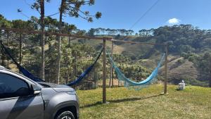 圣本图-杜萨普卡伊Chalé Refúgio Olíviah的田野里停着一辆汽车，旁边是一张吊床。 更多8张照片