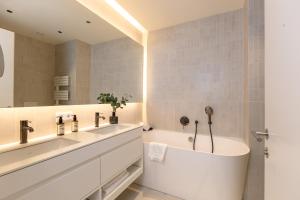 a bathroom with two sinks and a bath tub at BLOOM-Living in Linz +33 photos