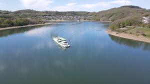 a boat in the middle of a river at Chalet am Biggesee in Olpe +22 photos