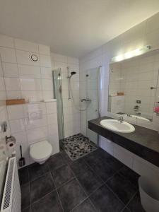 a bathroom with a toilet and a sink and a shower at Naturparkhotel Florence in Weissenbach am Lech +54 photos