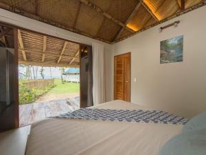 Un dormitorio con una cama y una ventana grande. en Private Beachfront El Nido - Sa Dulo Villa Diapila Bay, en El Nido