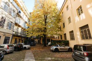 a parking lot with cars parked next to a tree at Carlo Alberto CHARM & TERRACE in Turin +45 photos