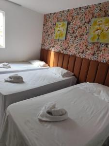 two beds with towels on them in a bedroom at Mandakaru Residence Flat da Isa 01 in Porto De Galinhas +43 photos