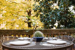 a table with plates and a cactus on it at Carlo Alberto CHARM & TERRACE in Turin
