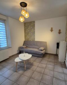 een woonkamer met een bank en een tafel bij Studio La Pause d'un Soir in Roye